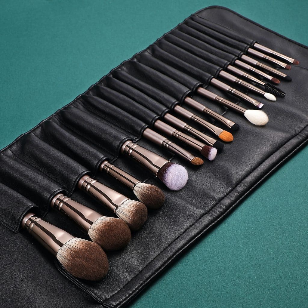 A makeup brush roll up bag filled with makeup brushes.